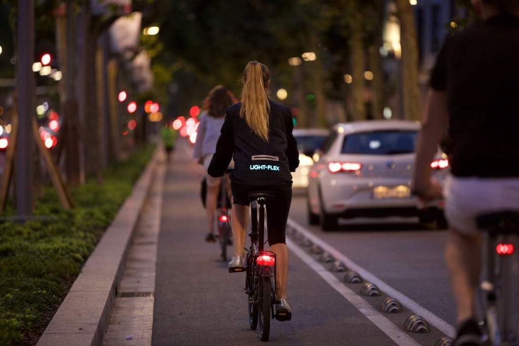 women riding a bike wearing Active Lights for electric vehicle safety clothing and garments.